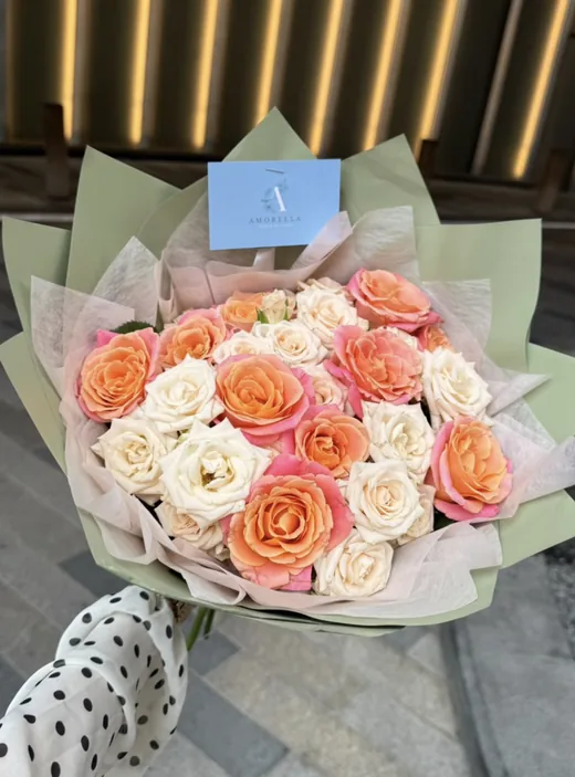 Peach and cream rose bouquet in sage wrap by Amorella Flower Boutique