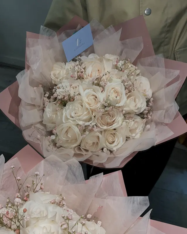 Cream rose bouquets in blush wrap by Amorella Flower Boutique