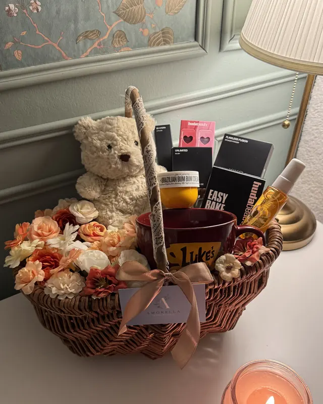 Gift basket with a teddy, chocolates and orange roses by Amorella Flower Boutique