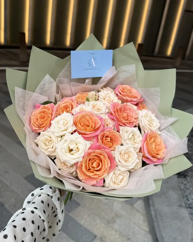 Peach and cream rose bouquet in sage wrap by Amorella Flower Boutique