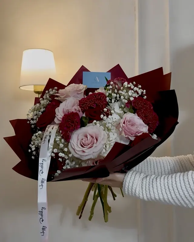 Red and pink rose bouquet with a ribbon message by Amorella Flower Boutique