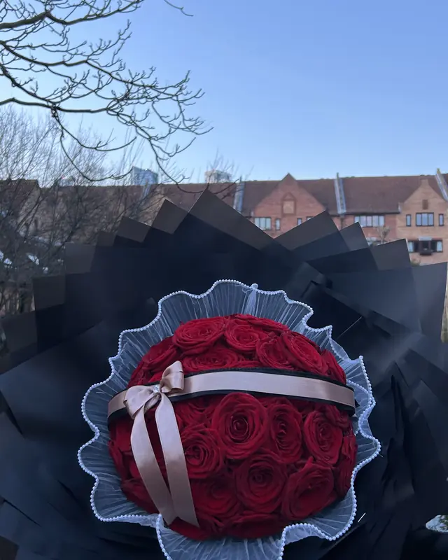 Red rose dome bouquet in black wrap by Amorella Flower Boutique